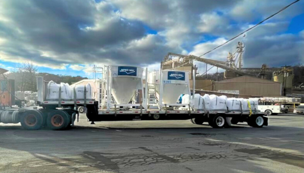 Truck transporting large silos for construction site